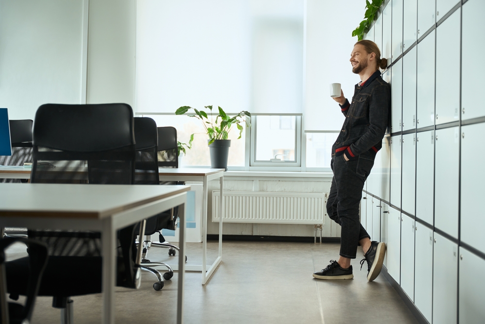 Break room lockers, as illustrated by this middle-age male employee leaning against a row of them, are today&#039;s solution for providing personal and professional space.